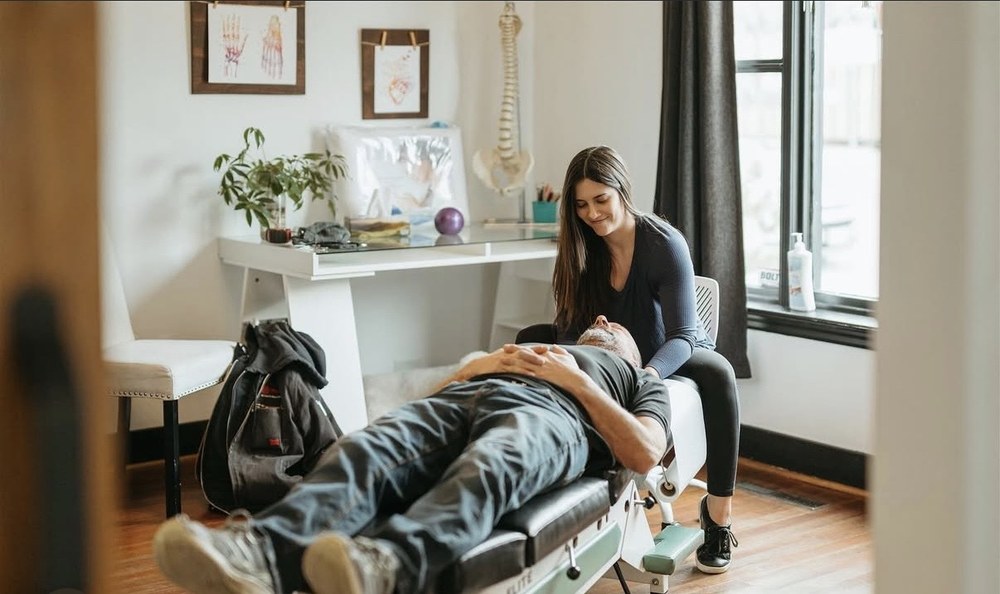 Dr. Maia Pidperyhora with a patient on the table in the treatment room